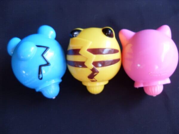 Marill, Pikachu, and Jigglypuff spinning top toys, back view.