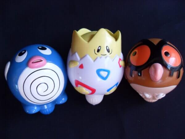 Togepi, Poliwag, and Hoothoot spinning top toys, front view.