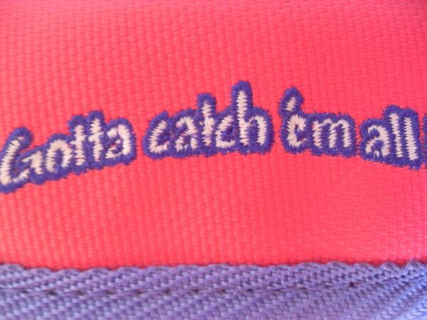 "Gotta catch 'em all!" embroidery detailing.