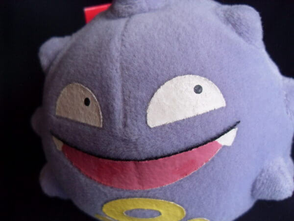 1999 Pokemon plush toy Koffing, face close-up.