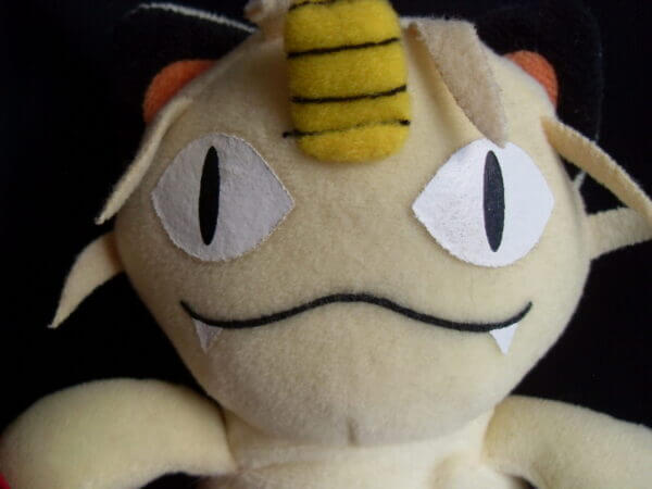1999 Pokemon plush toy Meowth, face close-up.