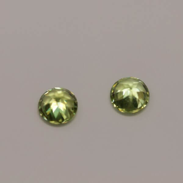 Green Sphene, 5mm round matched pair, bottom view.