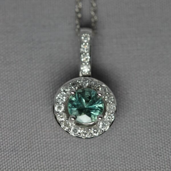 14kt White Gold, Diamond, and Green Montana Sapphire halo pendant, front view.