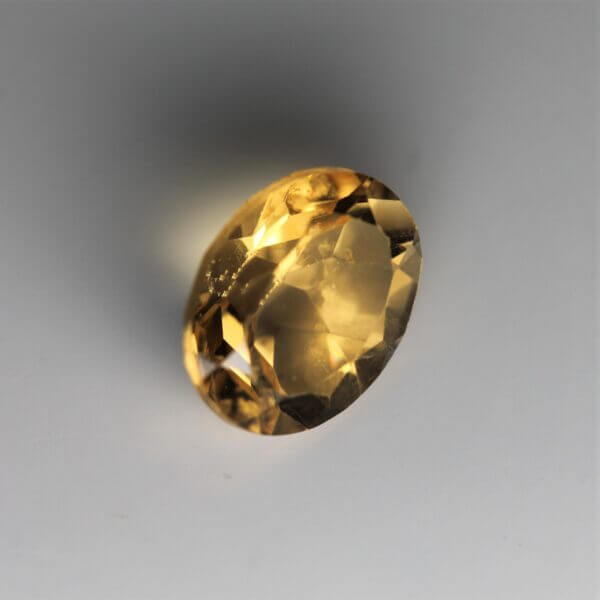 Citrine, 9x7mm oval cut, side view.