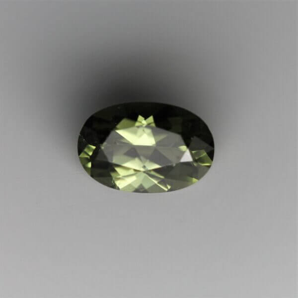 Diopside, 6x4mm oval cut, front view.