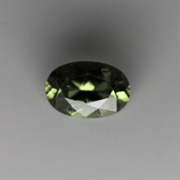 Diopside, 6x4mm oval cut, front view.