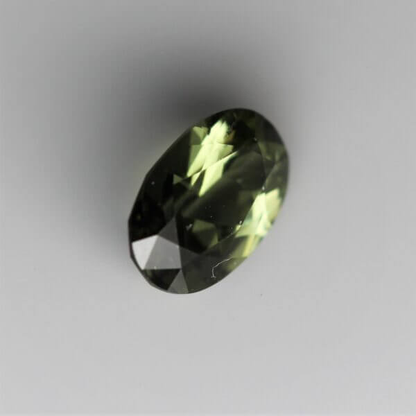 Diopside, 6x4mm oval cut, side view.